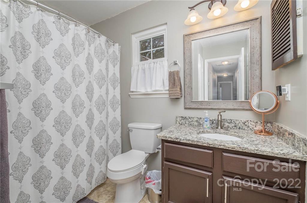 7201 Reedy Creek Road Charlotte, NC 28215 - Photo 25 of 30 a bathroom with a granite countertop sink and a mirror