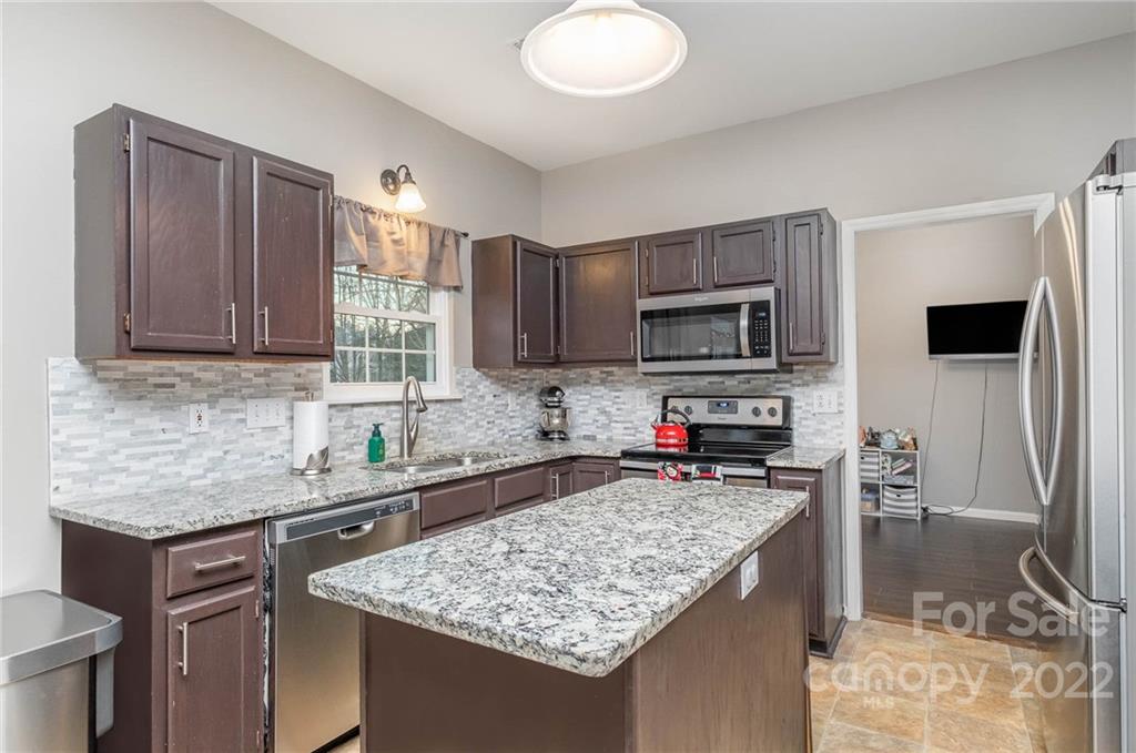 7201 Reedy Creek Road Charlotte, NC 28215 - Photo 9 of 30 a kitchen with stainless steel appliances granite countertop a sink stove and refrigerator