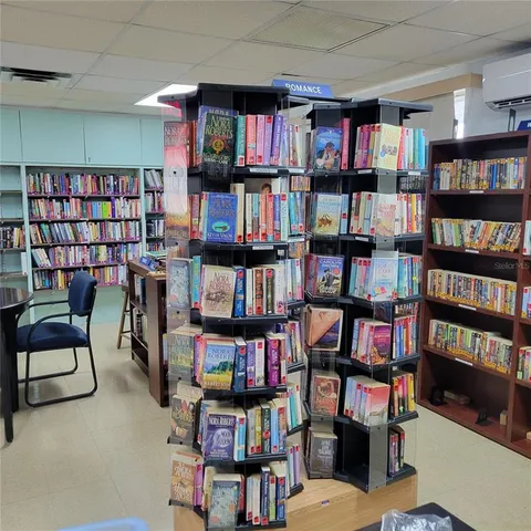 a living room with a book shelf and a book shelf