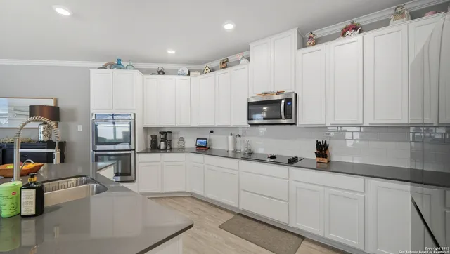 a kitchen with stainless steel appliances white cabinets and a sink