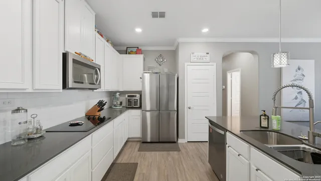 a kitchen with a sink a refrigerator and cabinets