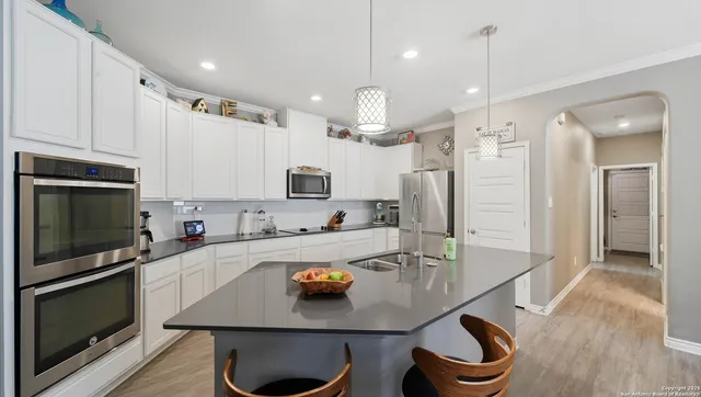 a kitchen with a sink a microwave a stove and refrigerator