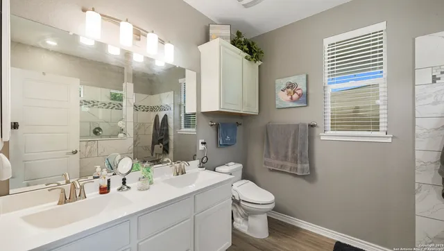 a bathroom with a sink toilet a mirror and shower