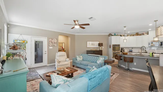 a living room with furniture kitchen view and a chandelier