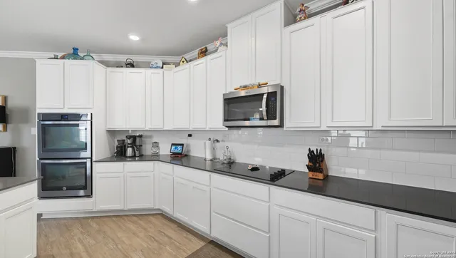 a kitchen with stainless steel appliances a sink a refrigerator and cabinets