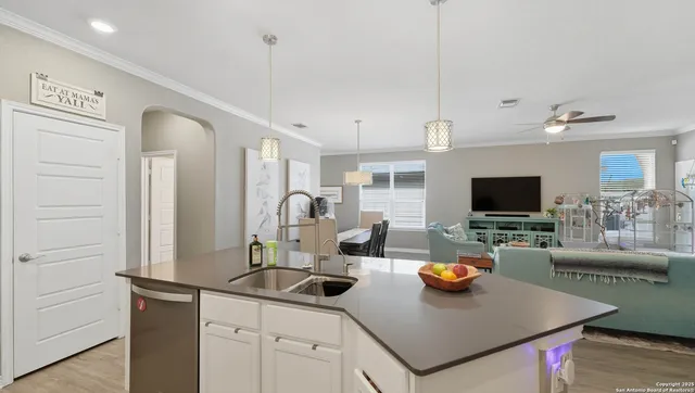 a living room with furniture a flat screen tv and kitchen view