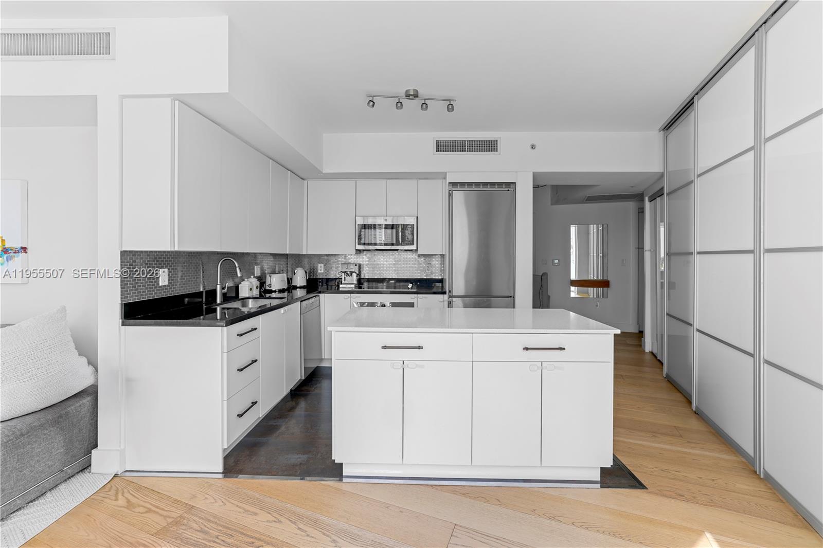 92 Southwest 3rd Street, Unit 1201 Miami, FL 33130 - Photo 11 of 31 a kitchen with stainless steel appliances kitchen island granite countertop a stove a sink and white cabinets