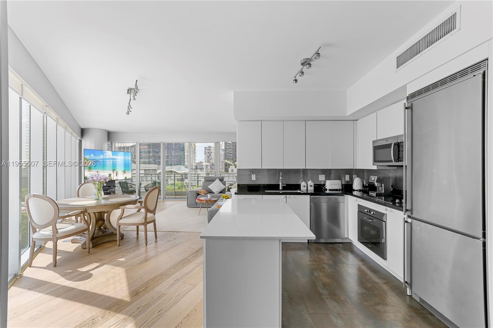 92 Southwest 3rd Street, Unit 1201 Miami, FL 33130 - Photo 9 of 31 a kitchen with a table chairs refrigerator and cabinets