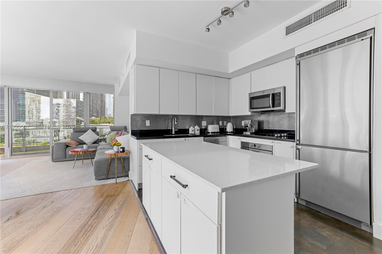 92 Southwest 3rd Street, Unit 1201 Miami, FL 33130 - Photo 10 of 31 a kitchen with kitchen island a white counter top space a sink a stove and a refrigerator