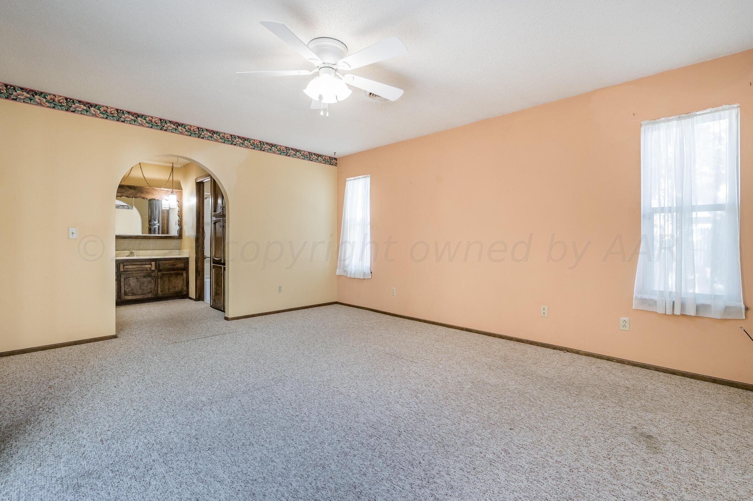 4502 Harvard Street Amarillo, TX 79109 - Photo 12 of 26 an empty room with windows and chandelier fan