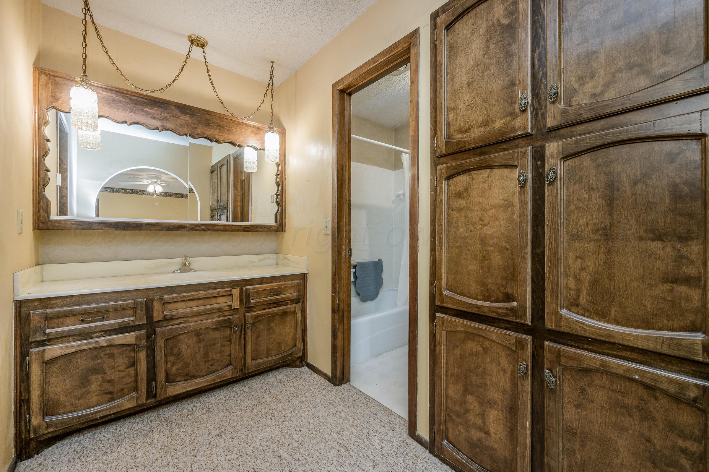 4502 Harvard Street Amarillo, TX 79109 - Photo 14 of 26 a bathroom with a sink and mirror