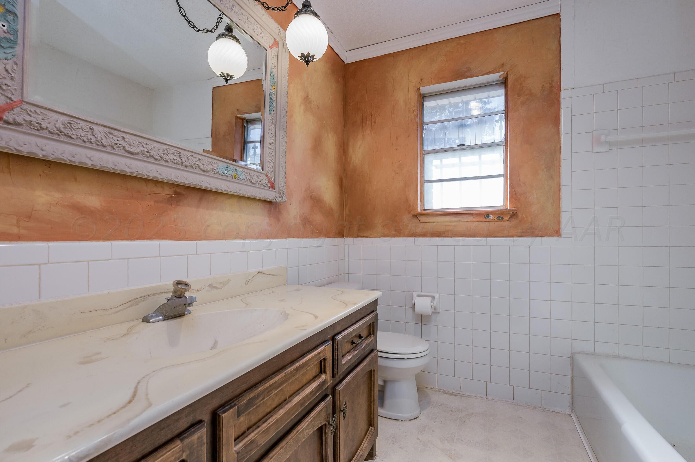 4502 Harvard Street Amarillo, TX 79109 - Photo 19 of 26 a bathroom with a sink a toilet and bathtub