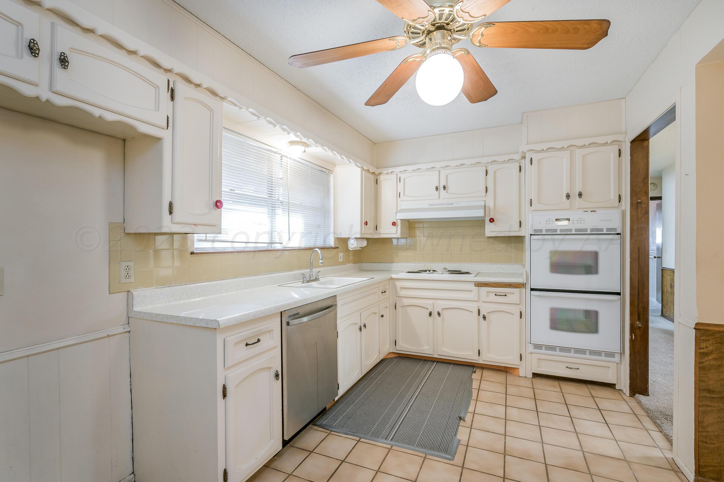 4502 Harvard Street Amarillo, TX 79109 - Photo 5 of 26 a kitchen with white cabinets appliances and a sink