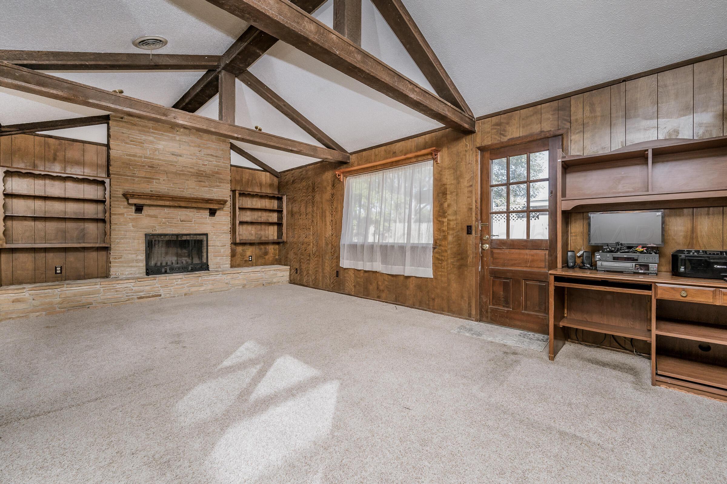 4502 Harvard Street Amarillo, TX 79109 - Photo 10 of 26 a view of an empty room with a fireplace and a window