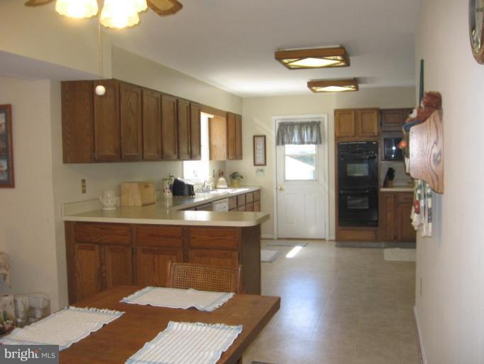 4325 Dunn Road Huntingtown, MD 20639 - Photo 12 of 23 a kitchen with kitchen island a sink stainless steel appliances and cabinets