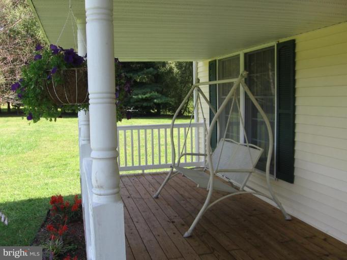4325 Dunn Road Huntingtown, MD 20639 - Photo 8 of 23 a view of a porch with a table and chairs