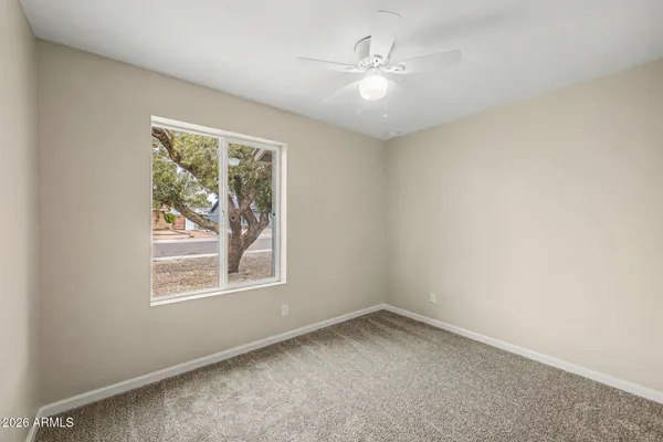 an empty room with a chandelier fan