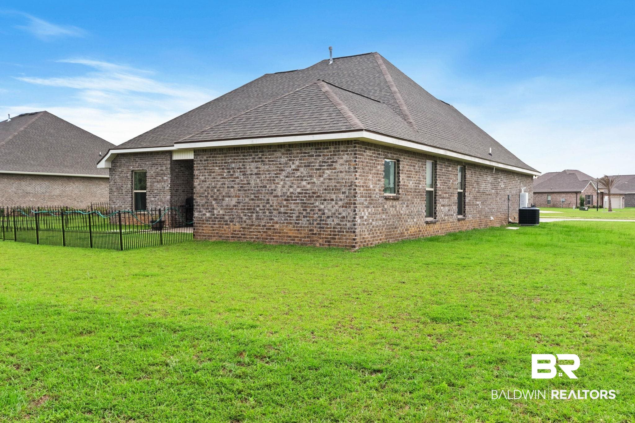 22244 Hibiscus Circle Foley, AL 36535 - Photo 6 of 51 Expansive green lawn surrounds this brick exterior home with a dark shingle roof