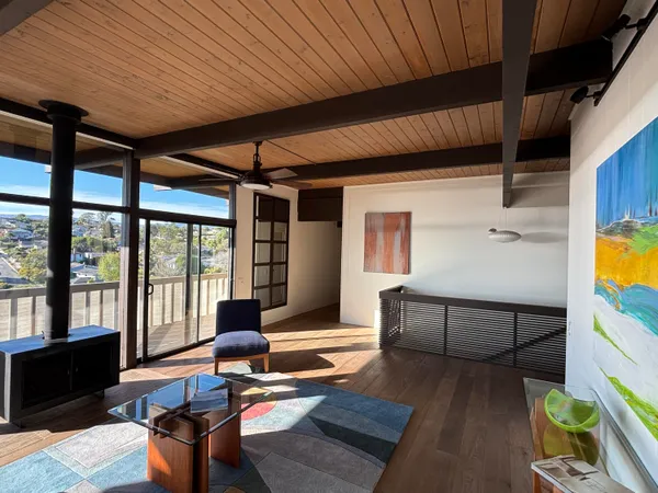 a living room with furniture and floor to ceiling windows
