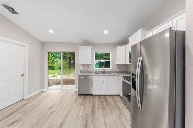 a kitchen with stainless steel appliances a refrigerator sink and cabinets