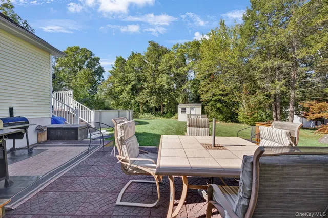 a backyard of a house with table and chairs