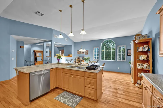 a kitchen with a sink stove and wooden floor