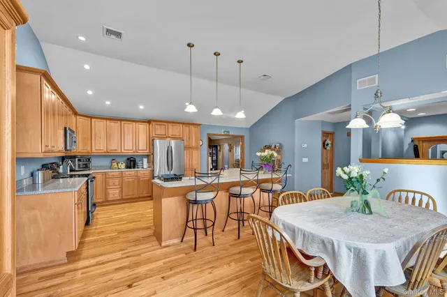 a view of a dining room and livingroom with furniture wooden floor a chandelier