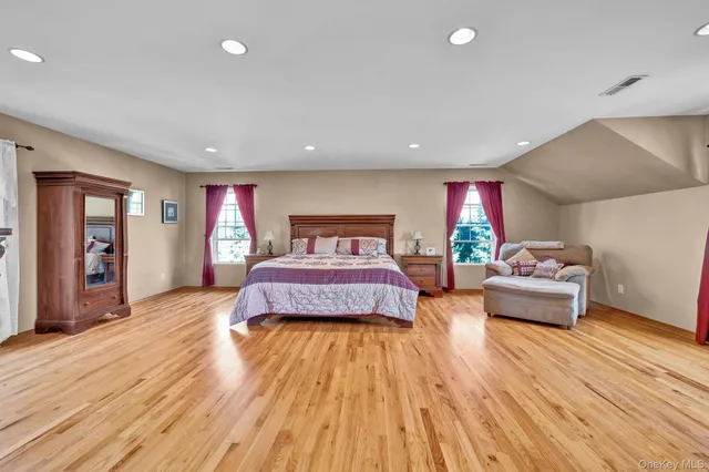 a spacious bedroom with a bed and glass windows