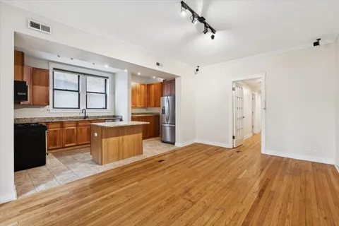 a large kitchen with granite countertop a sink counter space and stainless steel appliances