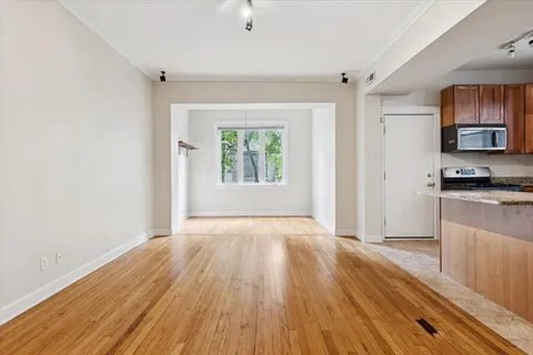 an empty room with wooden floor and a window