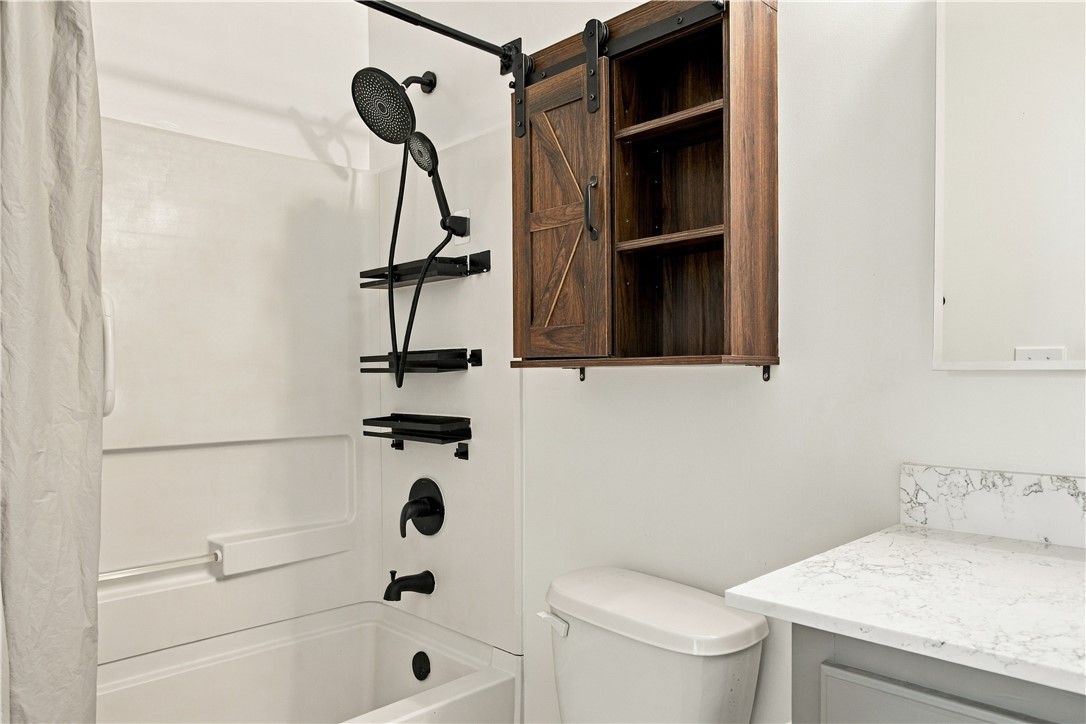 636 Lookover Drive Anderson, SC 29621 - Photo 32 of 34 Modern finishes define this bathroom, showcasing a stone-topped vanity and a tub-shower combination.