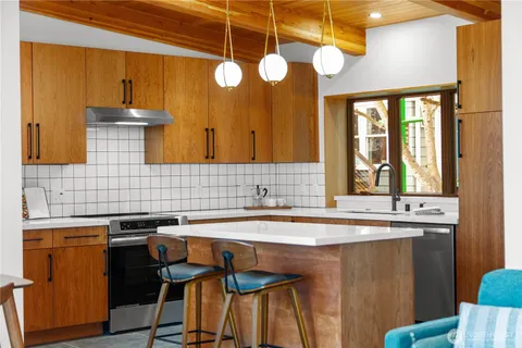 a kitchen with a sink a counter space and dining table