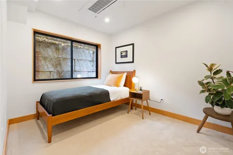 a bedroom with a bed chair and painting on the wall