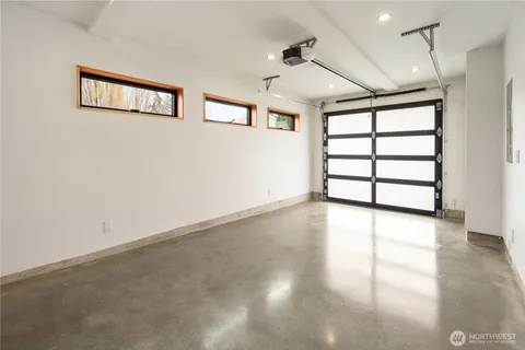 an empty room with windows and ceiling fan