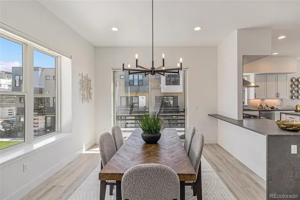 a dining room with furniture potted plants and wooden floor