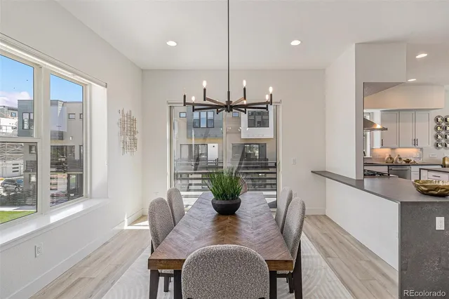 a dining room with furniture potted plants and wooden floor