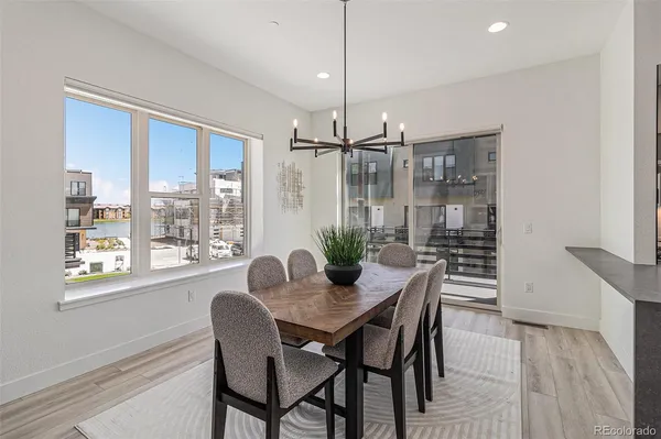 a dining room with furniture a chandelier and wooden floor