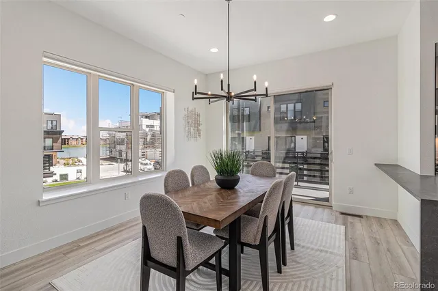a dining room with furniture a chandelier and wooden floor