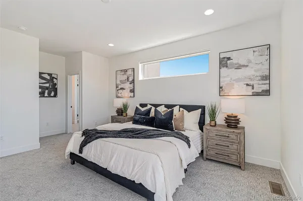 a spacious bedroom with a bed and a painting on the wall