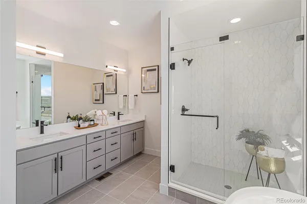 a bathroom with a double vanity sink mirror and shower