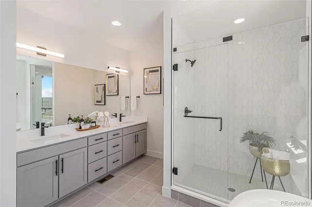a bathroom with a double vanity sink mirror and shower