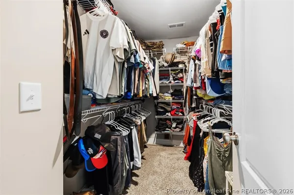a view of walk in closet with clothes and shoes