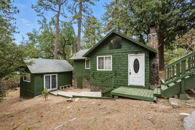 a view of a house with a yard and large trees