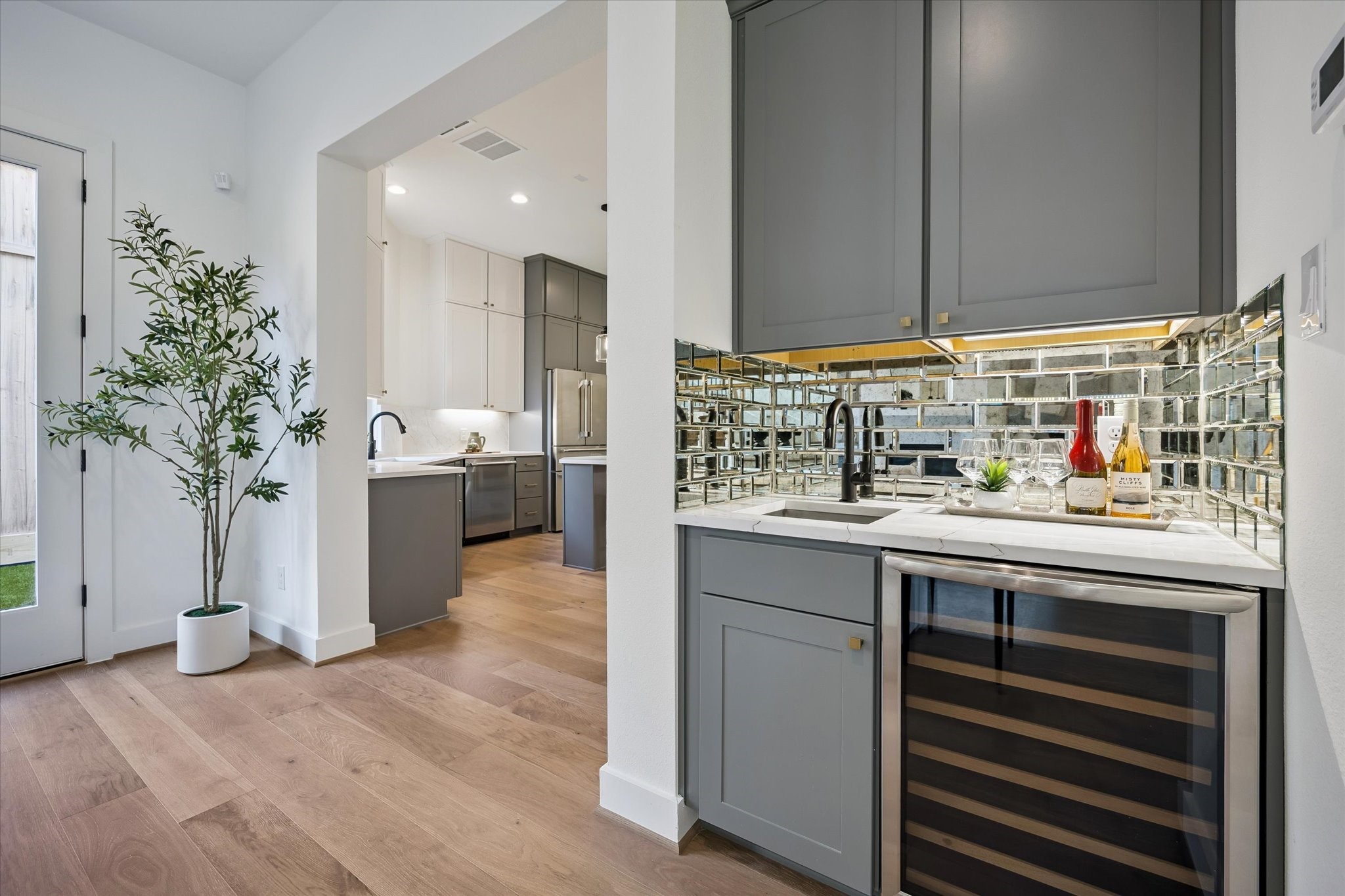 5329 Dora Street Houston, TX 77005 - Photo 17 of 43 A distinctive mirrored backsplash elevates this wet bar, conveniently located just off the living area and perfect for entertaining.