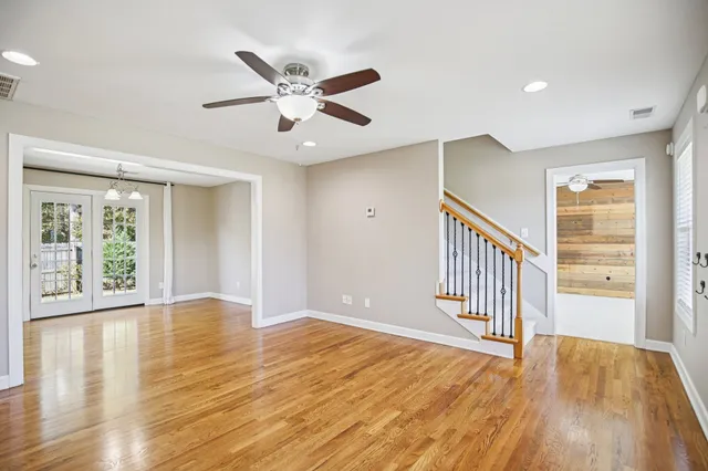 a view of a hallway with wooden floor and staircase