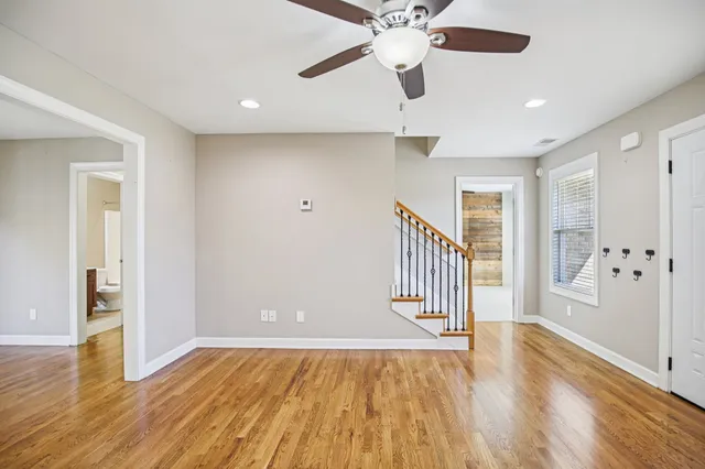 a view of a hallway with wooden floor and staircase