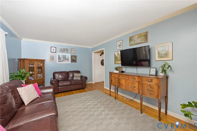 a view of a dining room with furniture a potted plant and wooden floor