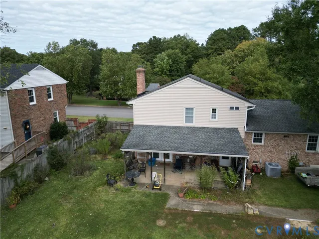 a backyard of house with a barbeque and a large tree