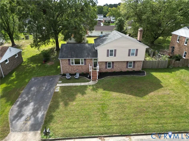 an aerial view of a house with a garden and lake view