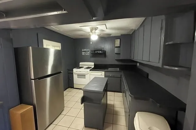 a kitchen with stainless steel appliances granite countertop a refrigerator a stove and a sink